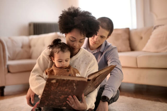 photo of woman holding brown book with her child 3818561